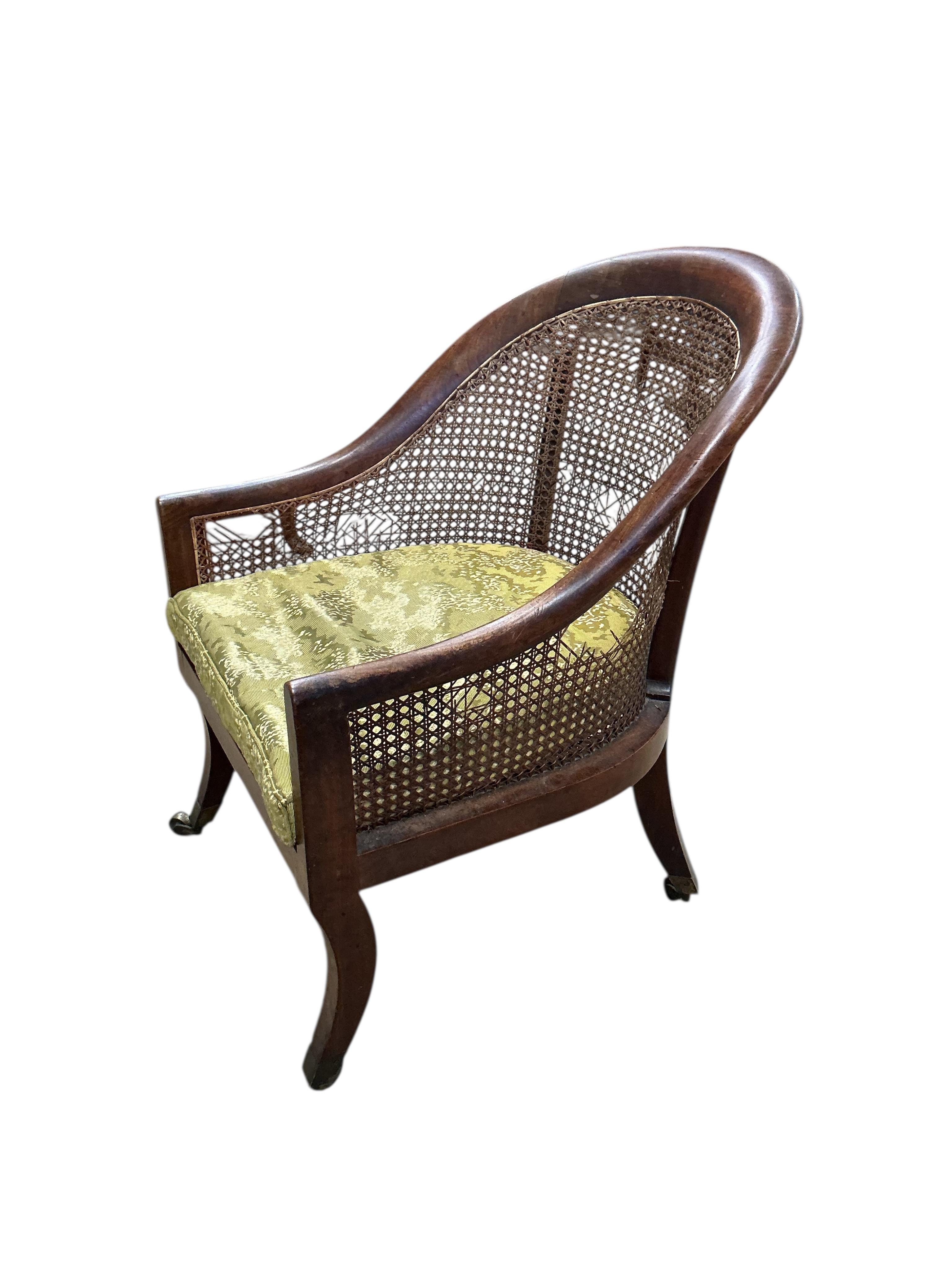 A Regency mahogany caned bergere armchair, (damaged cane) together with a Regency simulated rosewood and brass caned bergere armchair, larger width 49cm, depth 60cm, height 83cm